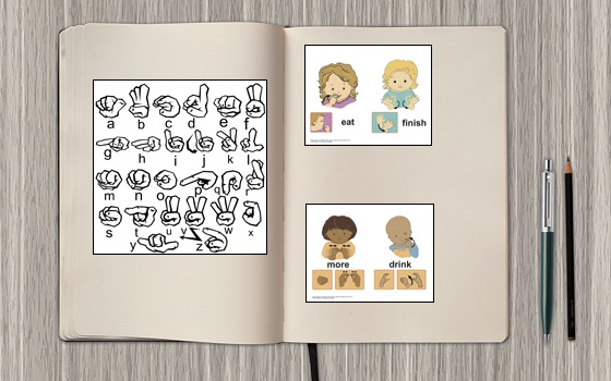 Immagine di un quaderno aperto con delle immagini dell'alfabeto manuale della ASL e immagini di segni in ASL.
