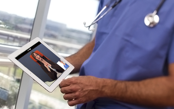 Foto medico con tra le mani un tablet, in collegamento con un interprete VEASYT Live!