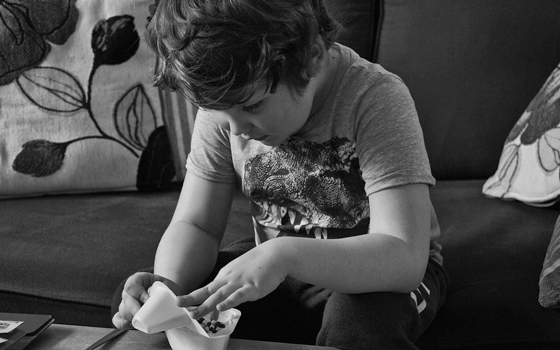 Foto in bianco e nero di un bambino che prepara la merenda.